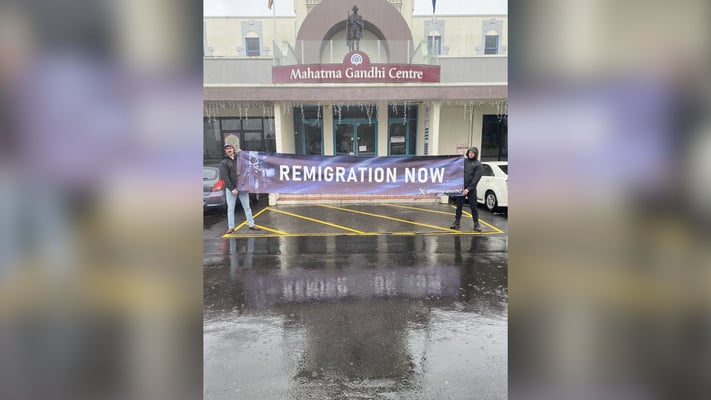 The two members of a group calling itself Remigration New Zealand gathered outside the Mahatma Gandhi Centre in Eden Terrace.